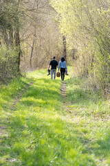 couple cheminant dans la forêt avec un panier de provision et des bottes