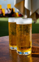 Fresh draught lager or IPA beer is glass served in outdoor cafe close up, pint of beer close up