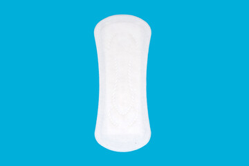 Feminine hygiene menstrual pad for the menstrual cycle on a blue background. Feminine hygiene product in the form of a sanitary napkin. Clean menstrual pad. Free space for text