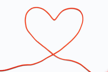 Red rope in the form of a heart on a white isolated background. The concept of love in the form of...