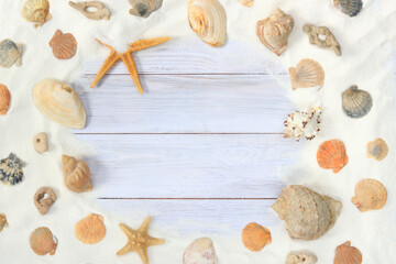 Fototapeta na wymiar Top view of a light wooden background with sand, shells and starfish. Summer composition, board background and sand. The concept of summer vacation, and resort