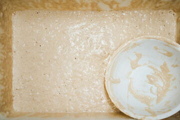 High view of recipient with fresh raw sourdough before it is used for bread preparation in bakery