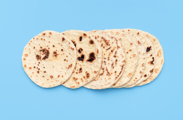 Homemade flatbread on a blue table. Top view with a pile of naan bread.