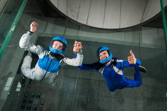 A man and a woman enjoy flying together in a wind tunnel. Free fall simulator