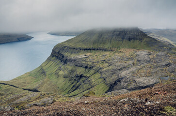 Aerial moody view from the Sornfelli mountain in Faroe Islands to the Vagar and Streymoy island, Denmark, Northern Europe, rainy and cloudy weather