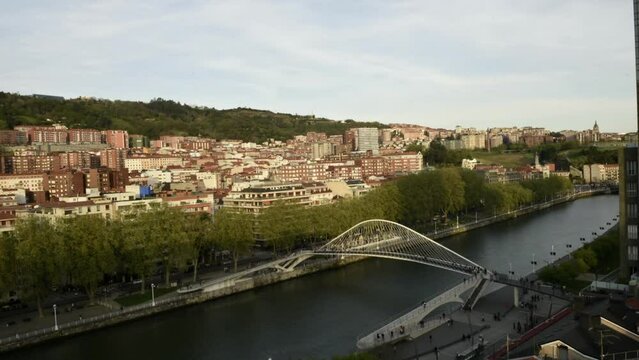 High perspective timelapse of Zubizuri arch footbridge crossing the Nervion River in Bilbao, Spain