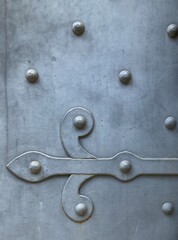 Weathered metal door and studs with flour de lis hinge, Ragusa, Sicily