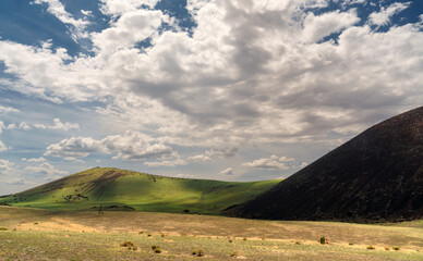 Obraz premium The monsoon rains bring water to the cinder cones and cover them with green grass in the San Francisco lava field north of Flagstaff, Arizona.