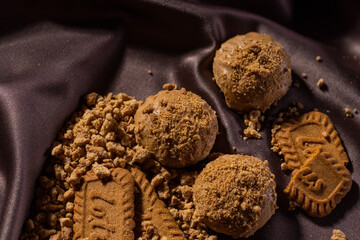 delicious Eid cake topped with lotus cream and adorned with delicate decorations, placed on a table covered with a rich brown satin cloth. colors and textures pop against the warm atmosphere