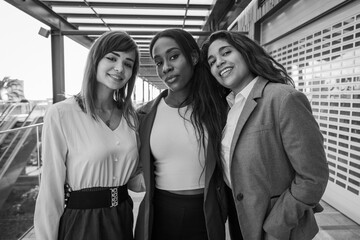 Three businesswomen smiling while together, colleagues at work, black and white photo