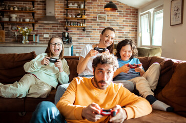 Young family playing video games together in the living room on a gaming console