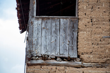 Old wooden fence on the wall of a house in the village.