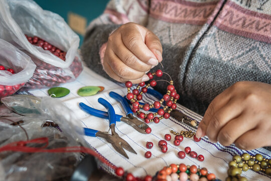 Hands of an unrecognizable woman working making handmade bracelets