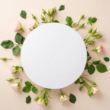 Simple yet elegant, top view flat lay features delicate roses arranged on a soothing beige background with an empty circle for promotional messages or branding