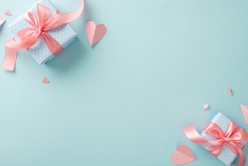 Mother's Day appreciation gift concept. Top view flat lay photo of beautiful present boxes with pink ribbons, and pink paper hearts on pastel blue background with copyspace