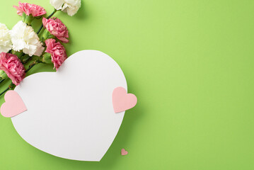 Lovely Mother's Day concept. Top view flat lay of carnation flowers, and pink paper hearts on a soft pastel green background, perfect for gifting, with empty heart for text or advert