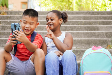 Happy multiethnic children using mobile phone for vlogging. New generations of influencers streaming out social media content, childhood, fun, two