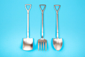 decorative fork and spoons in the form of spades on a colored background. food tools.