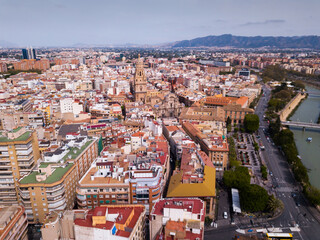 Fototapeta premium View from drone of residential areas and catholic cathedral belfry of Spanish town of Murcia on Segura river