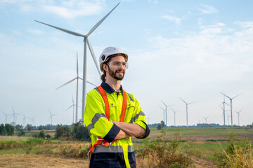 Engineer inspection and survey work in wind turbine farms rotation to generate electricity energy.