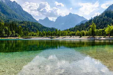 Beautiful turquoise lake with Alps mountains in the background. Beautiful sunny day in picturesque Slovenia. 