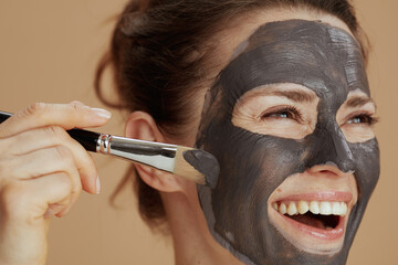 happy young female with brush and cosmetic mask