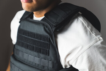 Close up of black bullet proof vest, body armor on man body. No face. High quality photo