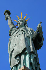 Fototapeta premium Detail of the Statue of Liberty on the Island of Swans in the center of the Seine river in Paris, France - Facing west, this copper sculpture is a gift from the American community in Paris