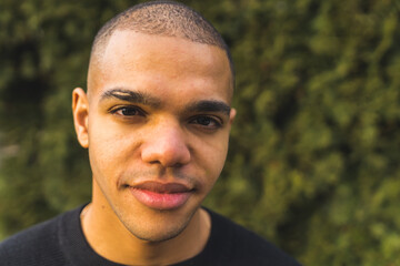 Close portrait of young African American man with a buzz cut looking into the camera. High quality...