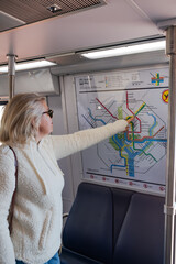 woman on the DC subway is looking at a subway map.