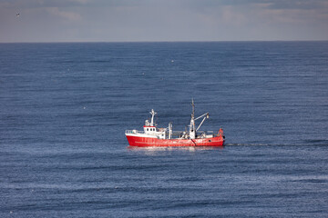 Fototapeta premium A red cutter the North sea close to Egmond aan Zee, Netherlands