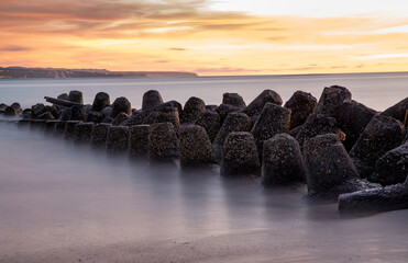 Sunset view at beach with tetrapods and long exposure water