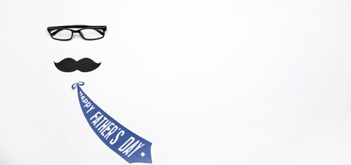 Composition with eyeglasses, paper mustache and necktie on white background with space for text. Father's Day celebration