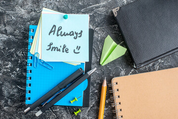 top view always smile note with pens and copybook on the gray background study note college school notepad lesson student paper
