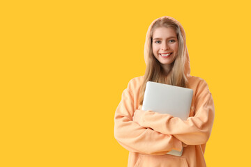 Female programmer with laptop on yellow background