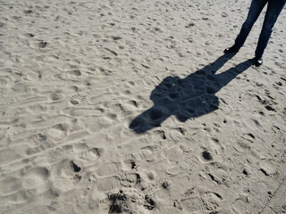 Shadow of feet on the sand