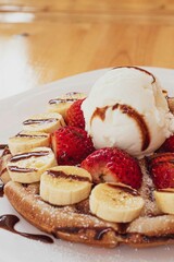 acercamiento de desayuno waffle con fresas banano y helado