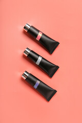 Tubes of glitter on pink background