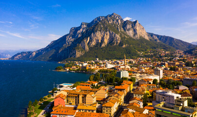 Picturesque view of small city of Lecco on shore of Lake Como on background of San Martino mountain on summer day, Italy - obrazy, fototapety, plakaty