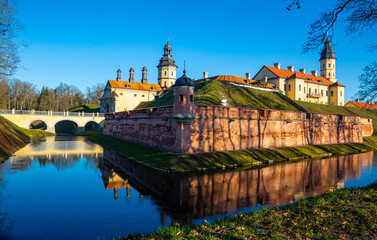 Winter view of belarusian medieval Nesvizh Castle with park and ponds on sunny day