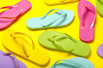 Colorful flip-flops on yellow background