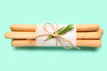 Bunch of tasty Italian Grissini on turquoise background