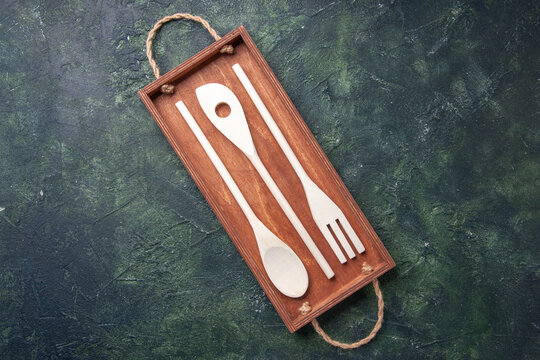 top view brown wooden desk with plastic utencils inside on dark background kitchen color cutting board photo box cuisine