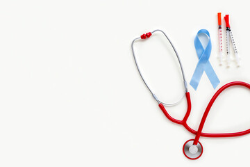 Awareness ribbon with syringes and stethoscope on white background. Diabetes concept