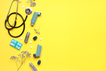 Asthma inhalers with stethoscope, pills and flowers on yellow background