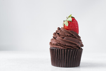 Chocolate cupcake with dark chocolate buttercream and strawberries, double chocolate cupcakes with american buttercream, tall swirl frosting on a cupcake with a strawberry