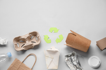 Recycling sign with garbage on grey background