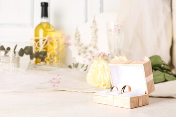 Box with wedding rings on white table, closeup