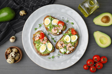 Delicious sandwiches with guacamole, shrimps and eggs on wooden table, flat lay