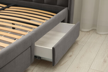 Fototapeta na wymiar Storage drawer for bedding under modern bed in room